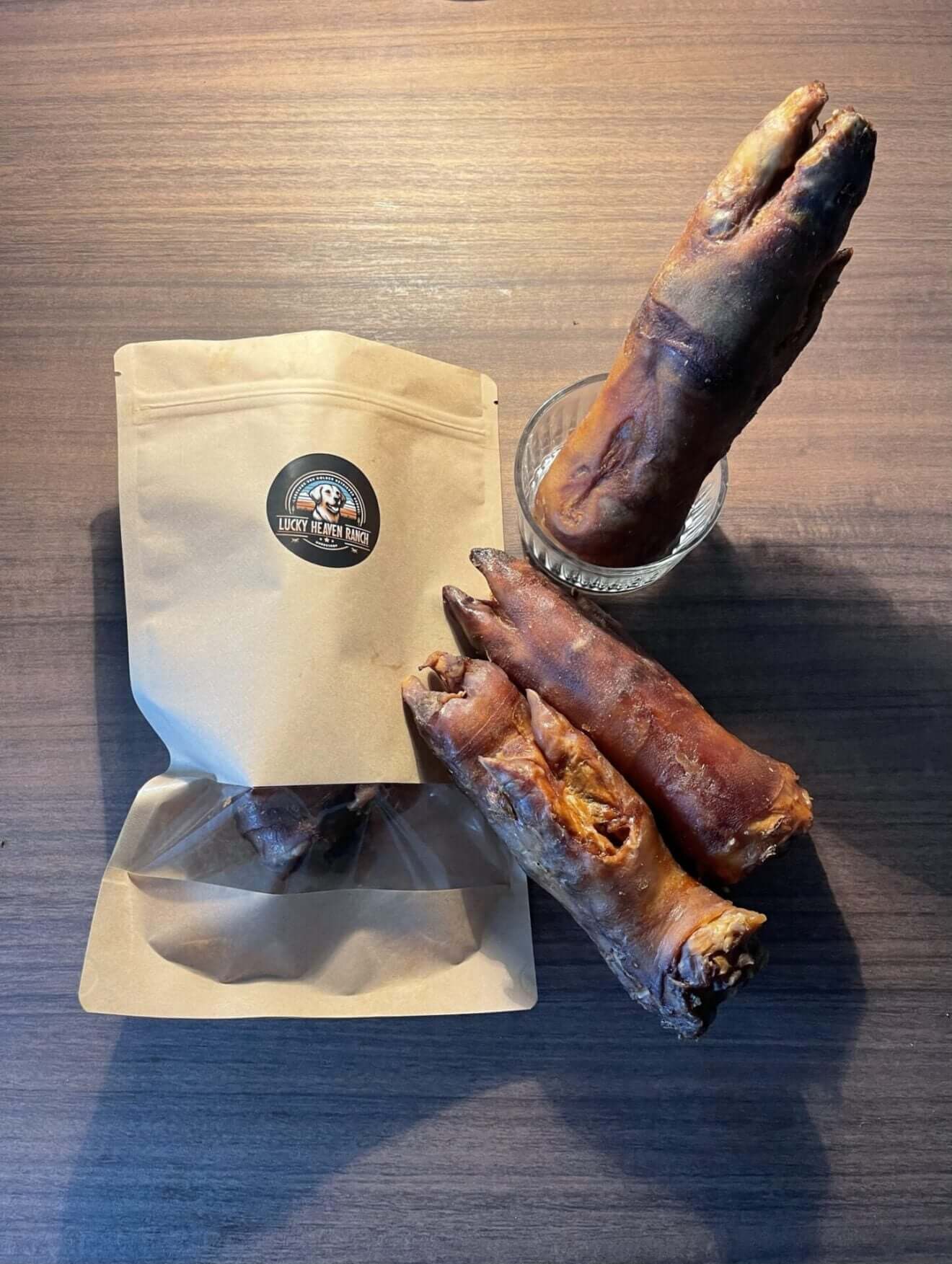 Schweinepfoten in einer Tüte mit einer Auswahl natürlicher Kauartikel für Hunde.